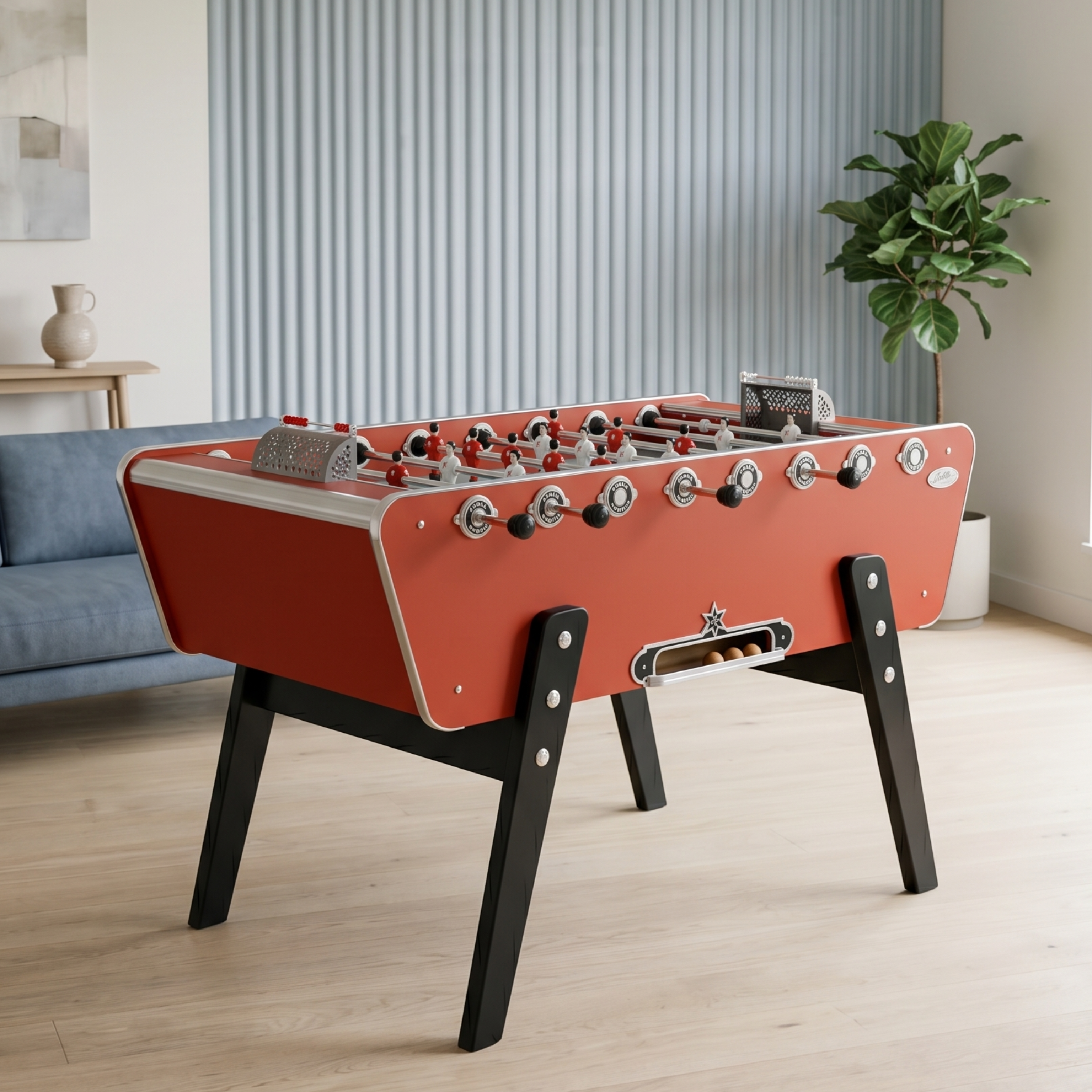 Baby-foot Stella Champion Collector rouge installé dans un salon chaleureux, le modèle mythique des cafés français avec pieds en hêtre massif pour une touche vintage et conviviale.